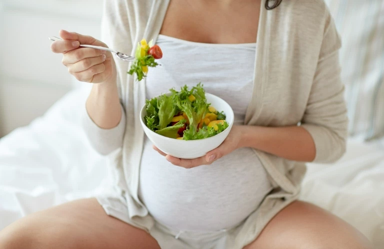 kobieta w ciąży jedząca sałatkę